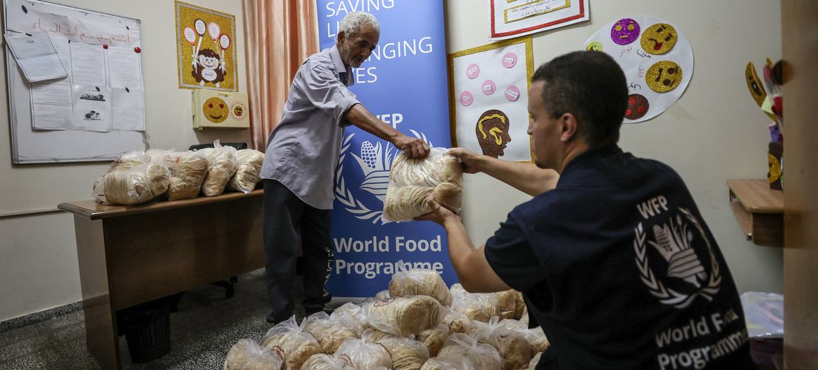 O Programa Mundial de Alimentos distribui pão em uma escola em Gaza, que agora é usada como abrigo
