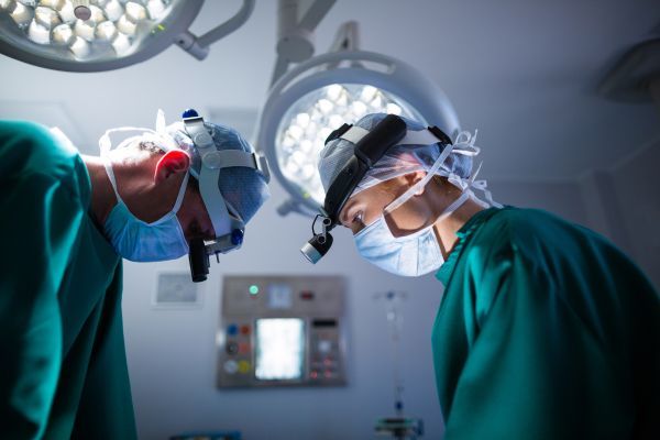 Médicos cirurgiões se preparando para uma cirurgia.