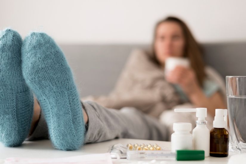 Pessoa com medicamentos e tomando os devidos cuidados contra a gripe.