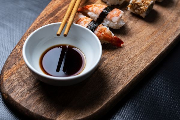 Pote com shoyu e um par de hashi.